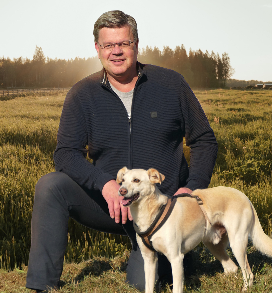 Oliver Petersen mit einem Hund auf einer Wiese